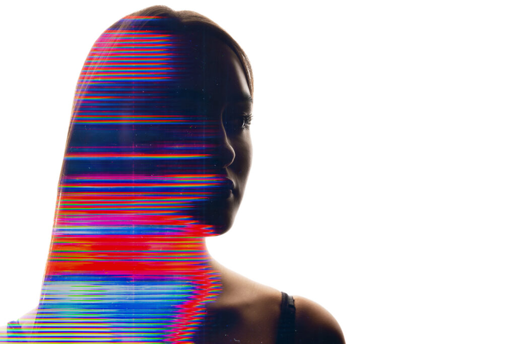 Portrait de profil d'une femme sur fond blanc, traversé de lignes colorées rouges et bleues façon glitch numérique, illustrant la mention obligatoire d'un mannequin IA. Photo de banque d'images, non générée par IA.